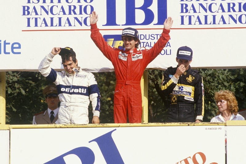 Alain Prost, 1st position, celebrates with Nelson Piquet, 2nd position and Ayrton Senna, 3rd position, on the podium.