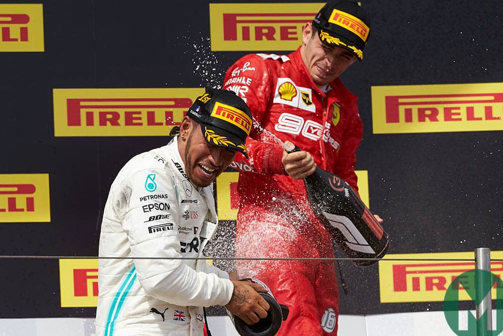 Lewis Hamilton and Charles Leclerc spray champagne on the podium at the 2019 French Grand Prix