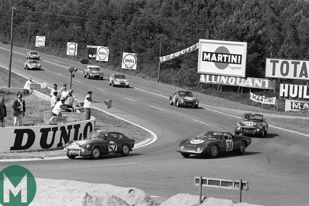 A Triumph Spitfire leads Jackie Stewart and Graham Hill's Rover-BRM at the 1965 Le Mans 24 hours