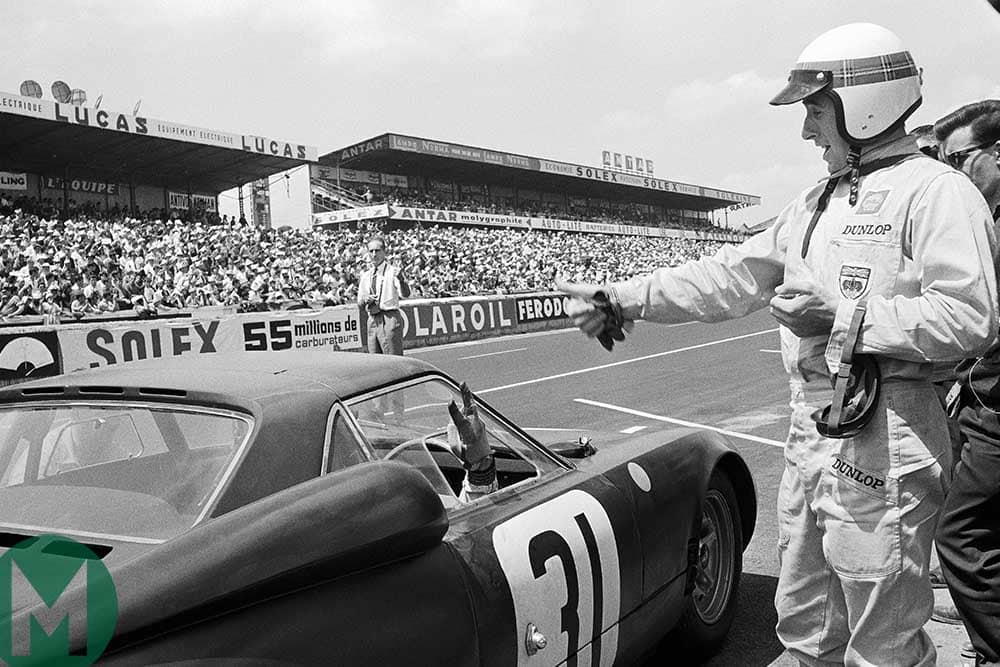 Graham Hill gestures at Jackie Stewart as he leaves the pits