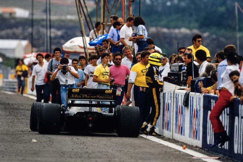 Ayrton Senna talks to his pit crew at the side of the track after running out of fuel in the 1986 F1 Portuguese Grand Prix