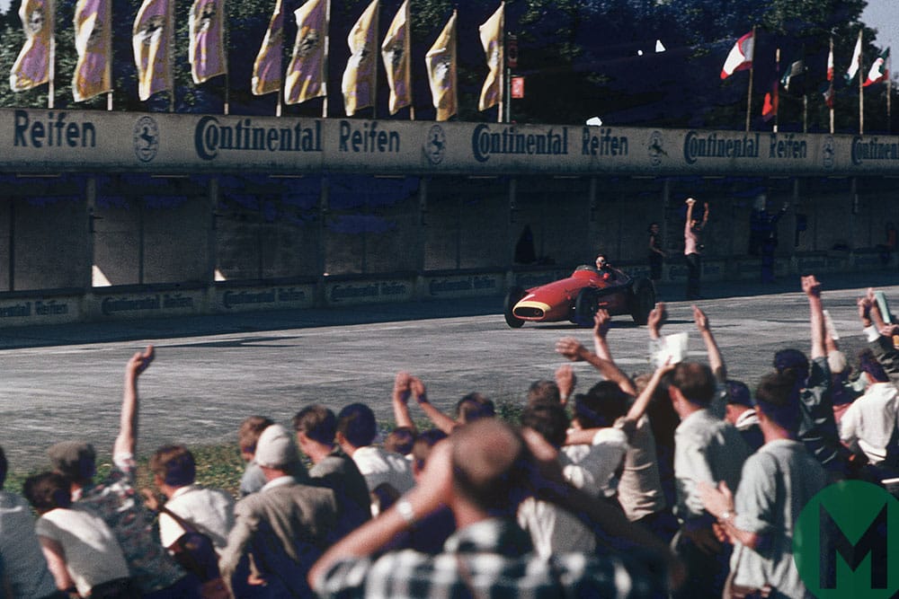 Juan Manuel Fangio takes the applause on the way to winning the 1957 German Grand Prix