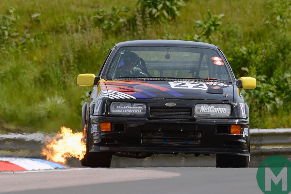 Flames burst from the exhaust of a Ford Sierra at the 2019 Thruxton Classic