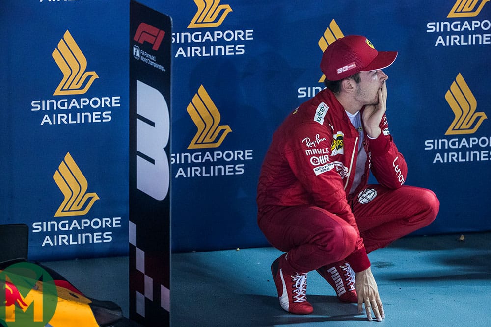 Charles Leclerc crouches in pac ferme at the end of the 2019 F1 Singapore Grand Prix