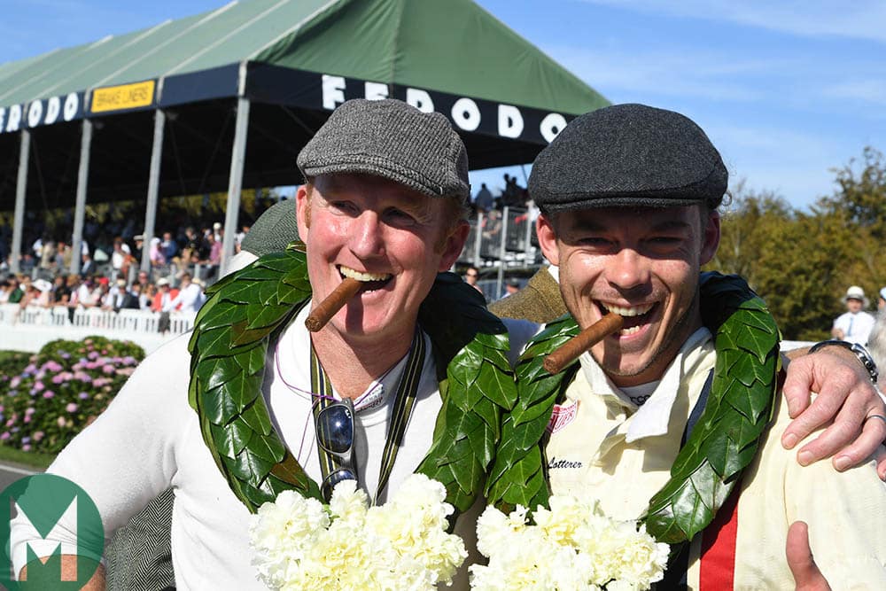 Andre Lotterer and Christopher Wilson, cigars in mouths, celebrating their victory in the RAC TT race at the 2019 Goodwood Revival