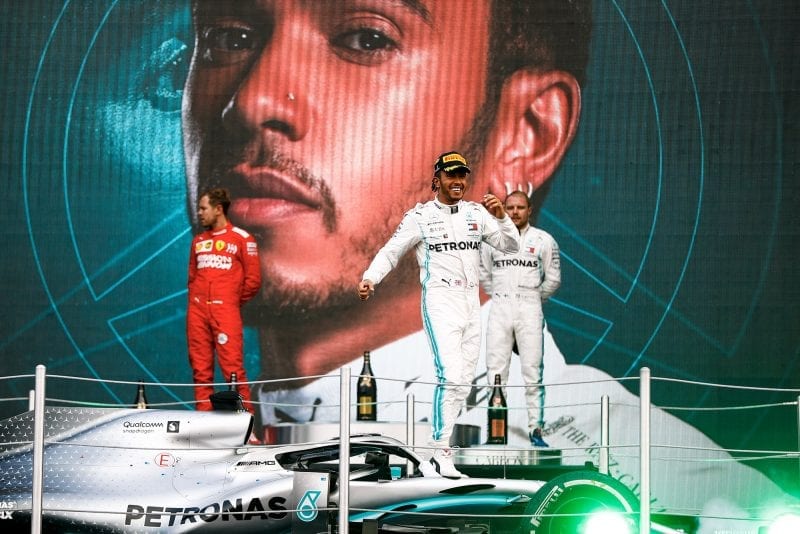 Lewis Hamilton is raised onto the podium with his car after winning the 2019 F1 Mexican Grand Prix