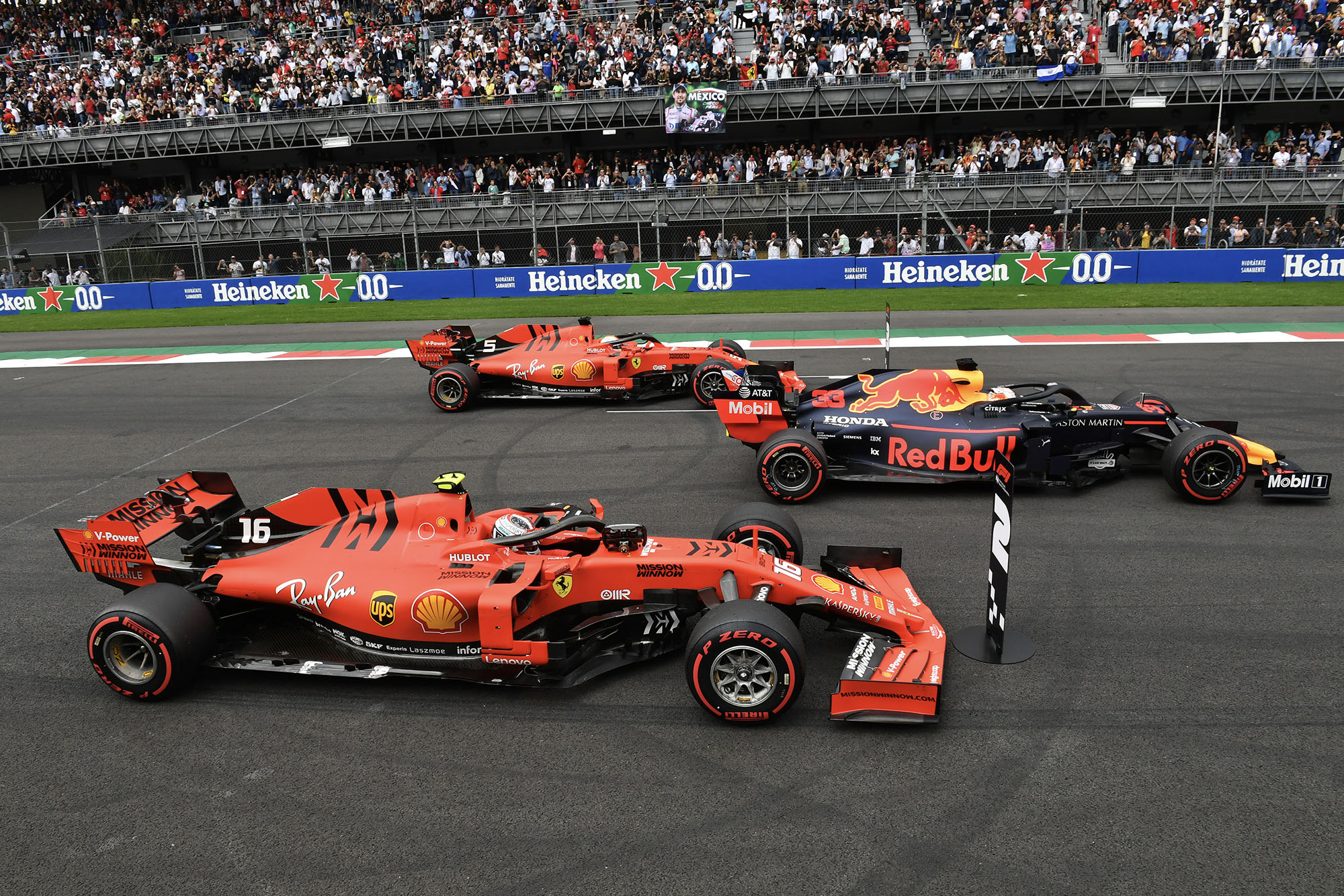 Max Verstappen parked in the pole-sitters position after qualifying for the 2019 F1 Mexican Grand Prix, flanked by two Ferraris