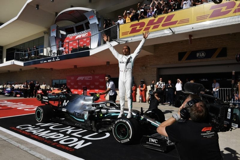 Lewis Hamilton stands on his Mercedes W10 in Parc Ferme at the United States Grand Prix after being confirmed as 2019 F1 champion