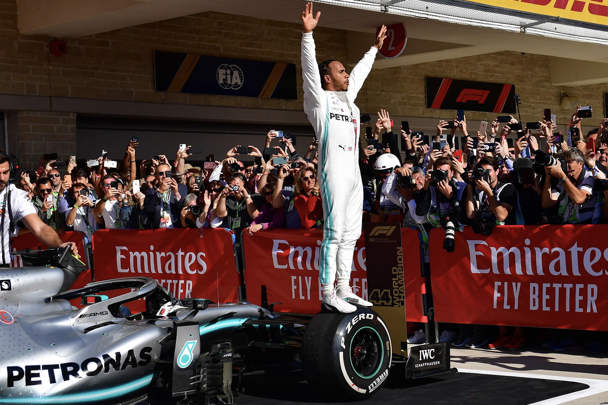 Lewis Hamilton stands on his car and raises his arms to the crowd after winning the 2019 F1 World Championship at the US GP