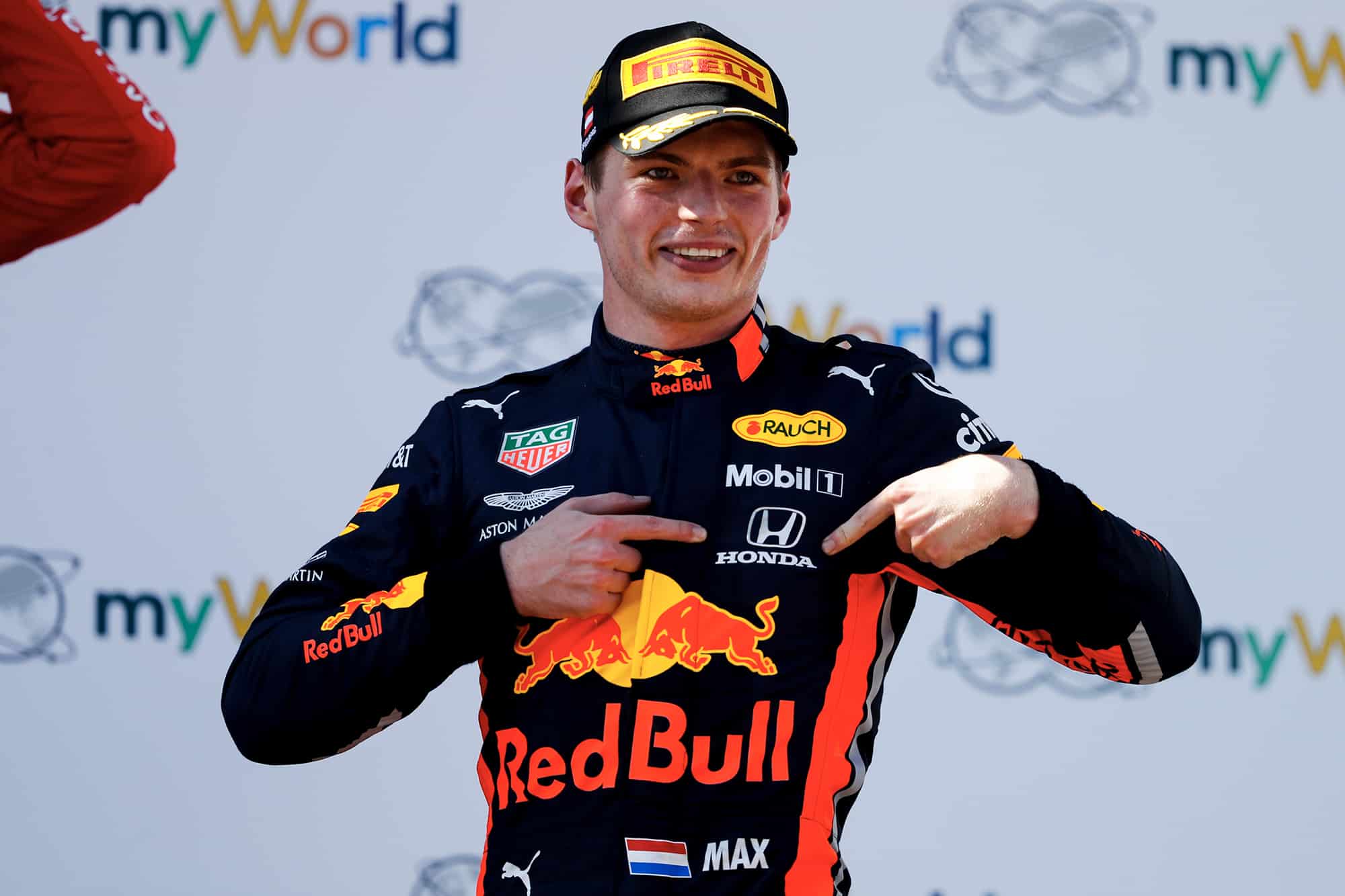 Max Verstappen points at his Honda badge after winning the 2019 Austrian Grand Prix
