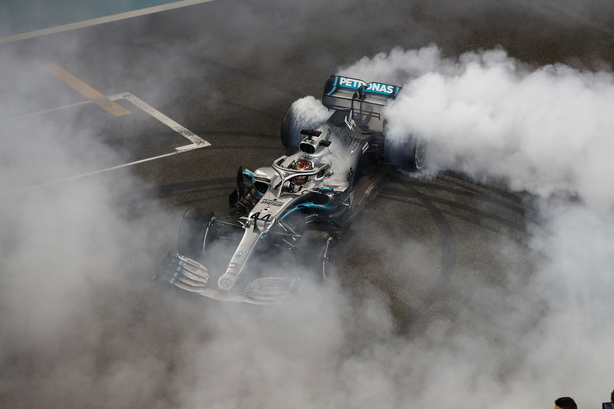 Smoke surrounds Lewis Hamilton's Mercedes as he performs donuts on the main straight in Abu Dhabi