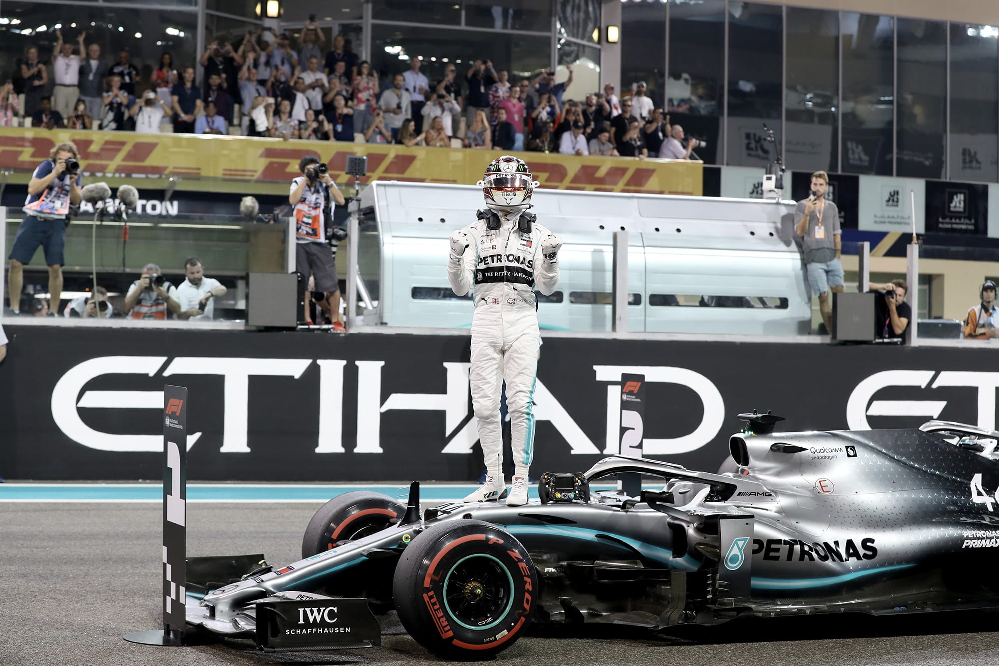 Lewis Hamilton stands on his Mercedes as he celebrates taking pole position for the 2019 Abu Dhabi Grand Prix