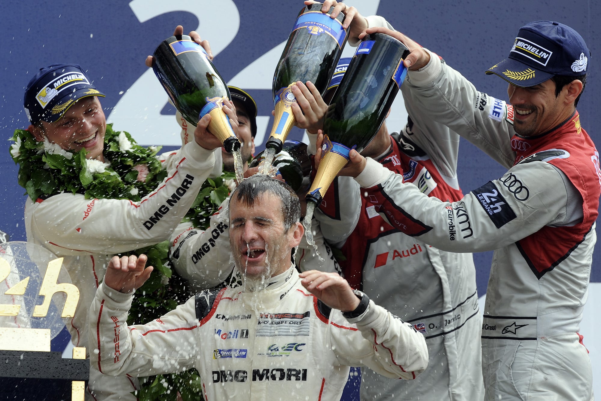 Romain Dumas drenched in champagne on the podium at Le Mans in 2016