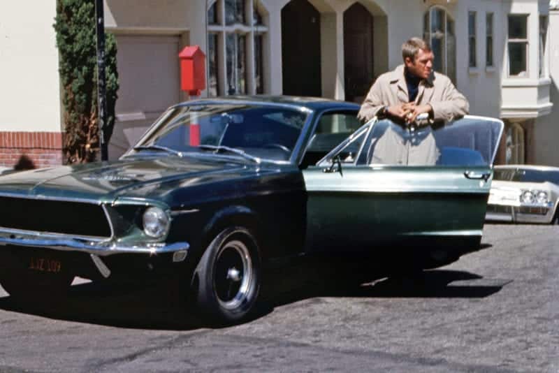 American actor Steve McQueen (1930 - 1980) as Frank Bullit next to a Ford Mustang 390 GT 2+2 Fastback in the american crime thriller movie 'Bullitt', San Francisco, 1968