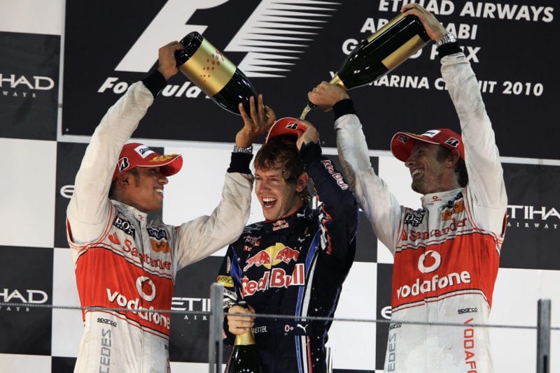 Lewis Hamilton and Jenson Button pour champagne over newly-crowned 2010 F1 champion Sebastian Vettel