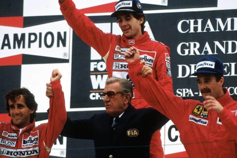 Jean Marie Balestre raises the arms of Nigel Mansell and Alain Prost in front of race winner Ayrton Senna at the 1989 Belgian Grand Prix