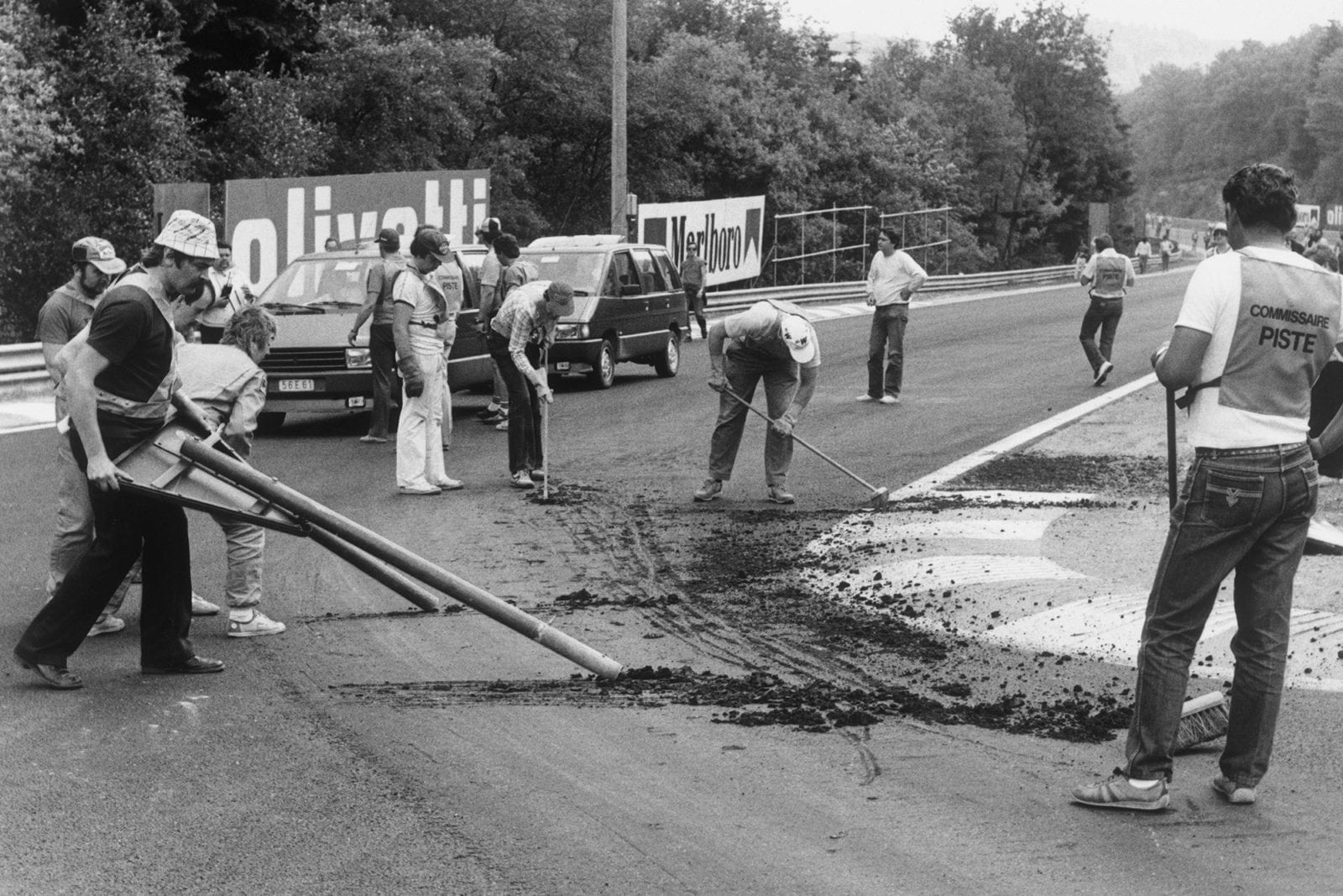 Workers try to repair the broken track surface ahead of the cancelled 1985 Belgian grand Prix