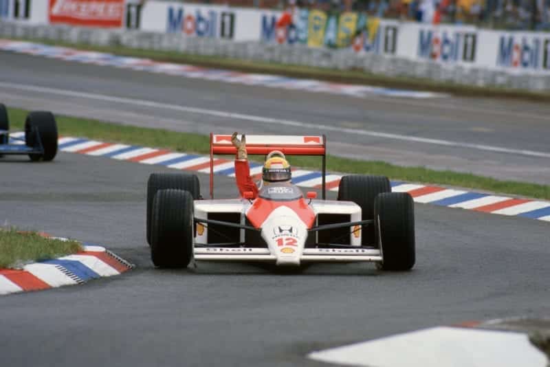 Ayrton Senna waves to fans from his McLaren Honda after winning the 1988 German Grand Prix