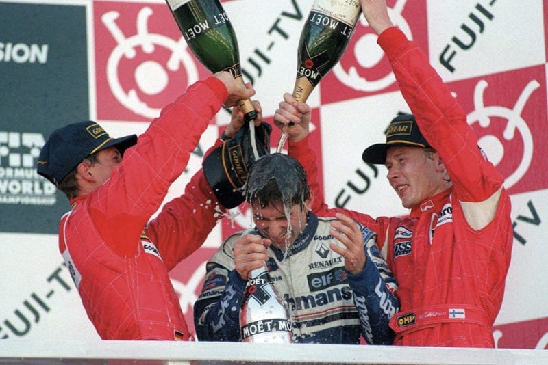 Damon Hill drenched in champagne by Michael Schumacher and Mika Hakkinen after winning the 1996 F1 championship