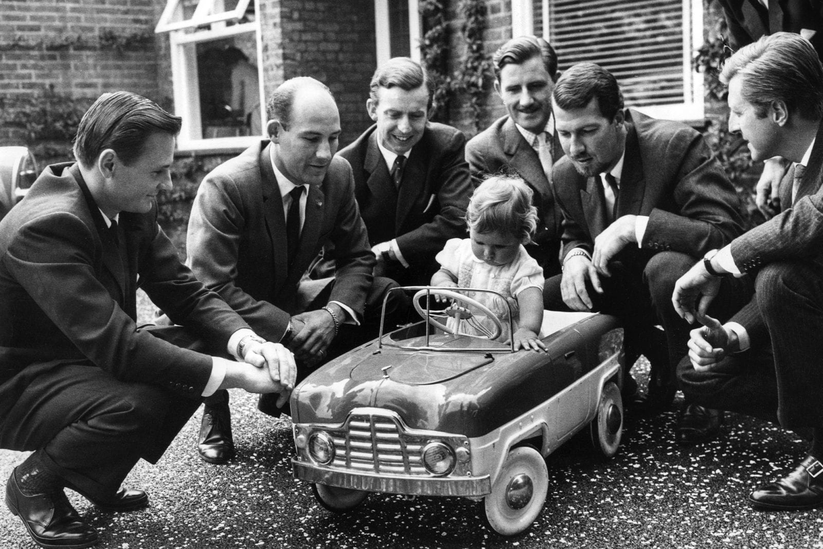 A young Damon Hill in a toy car with Bruce McLaren Stirling Moss Tony Brooks Graham Hill Jo Bonnier and Wolfgang von Trips
