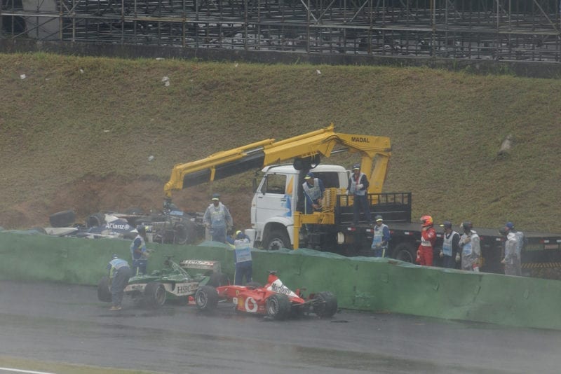 Michael Schumacher's Ferrari among the crashed cars at the trackside in the 2003 Brazilian Grand Prix