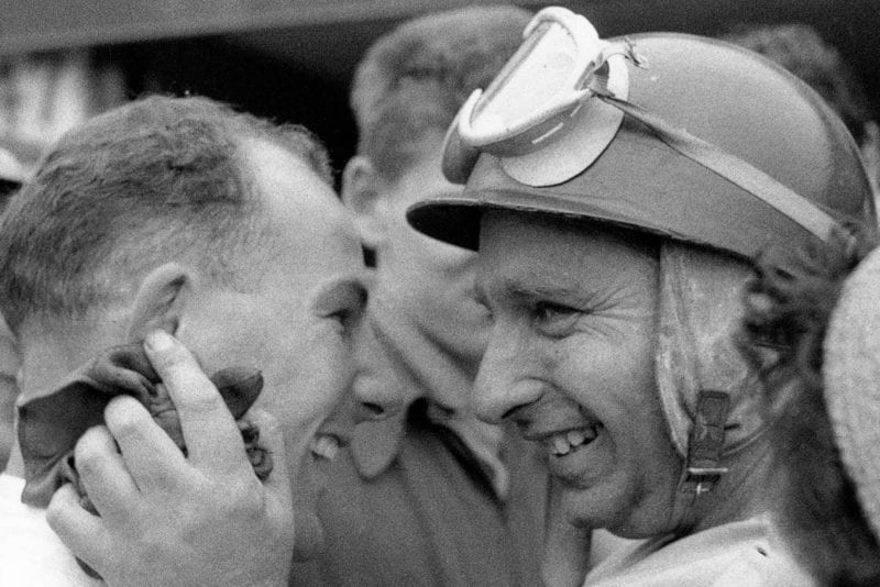 Stirling Moss and Juan Manuel Fangio share a laugh a the 1955 British Grand Prix