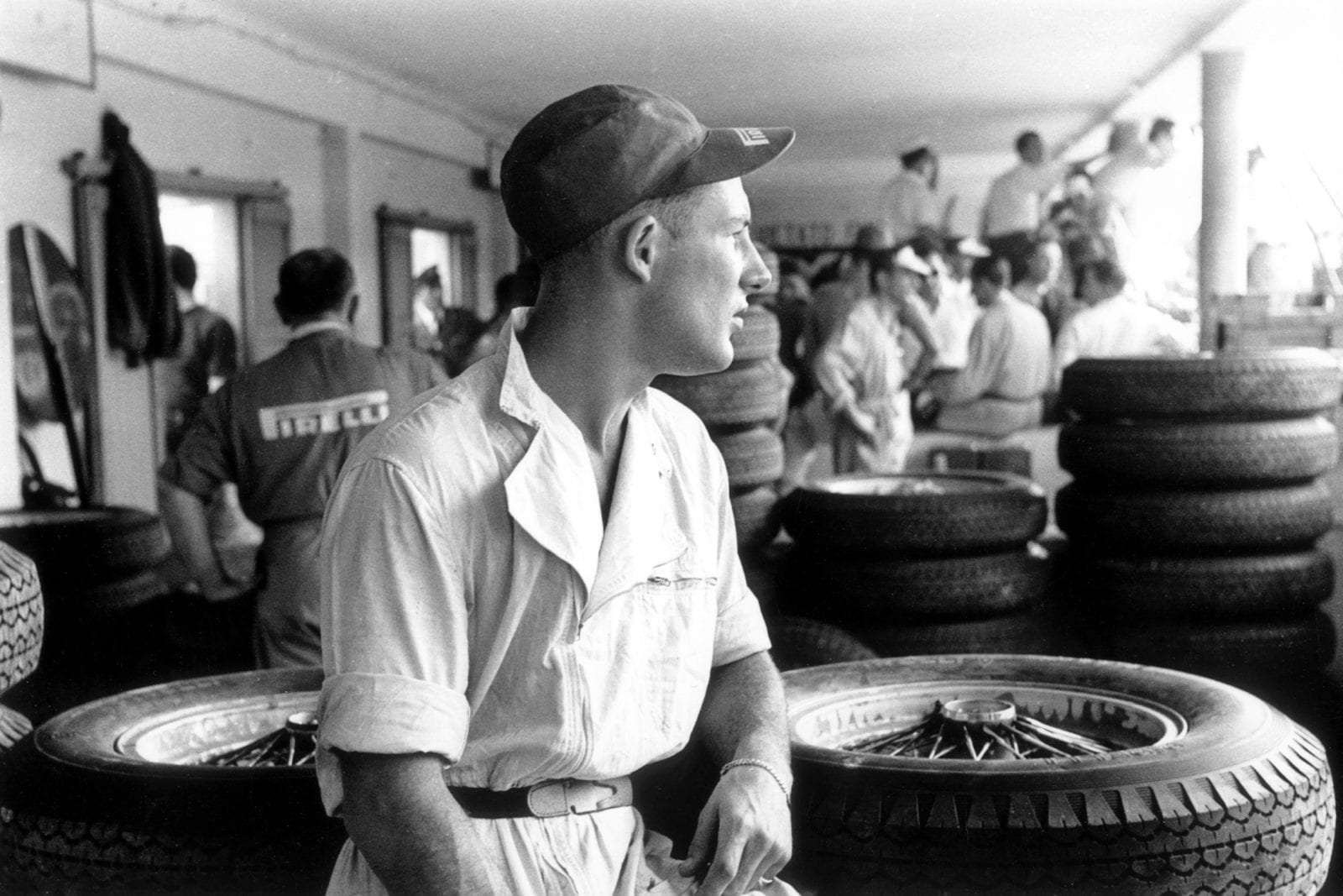 Stirling Moss surrounded by tyres in the pits at the 1954 Italian Grand Prix