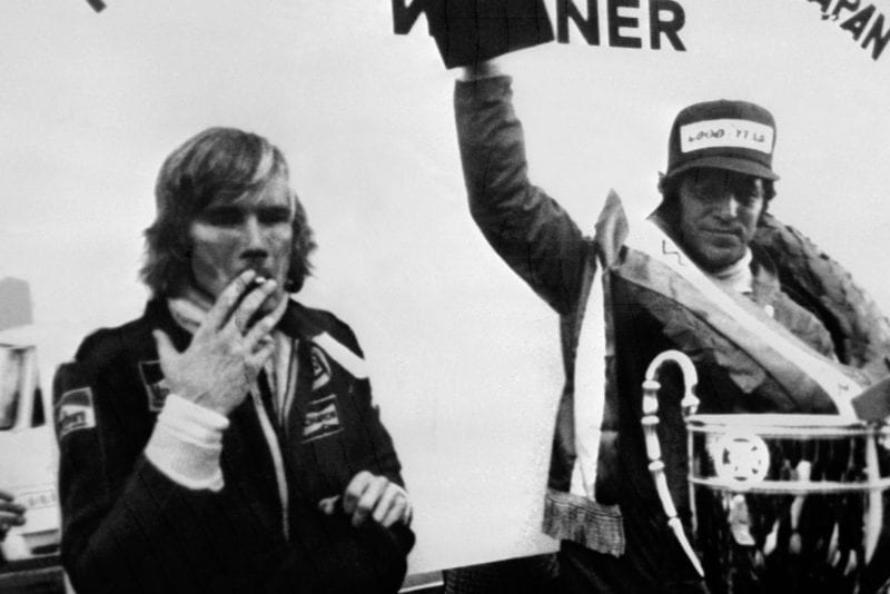James Hunt smokes a cigarette as Mario Andretti celebrates winning the 1976 Japanese Grand Prix