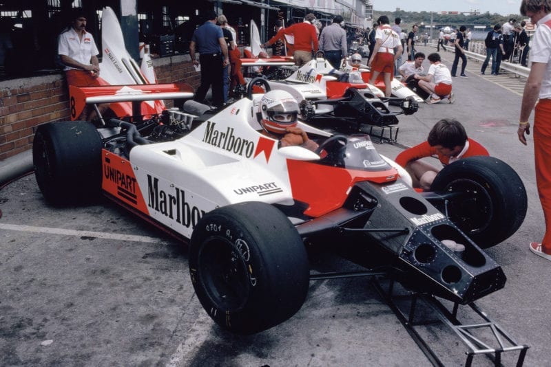 Niki Lauda sits in his McLaren in the pits at Kyalami during the 1982 South African Grand Prix weekend