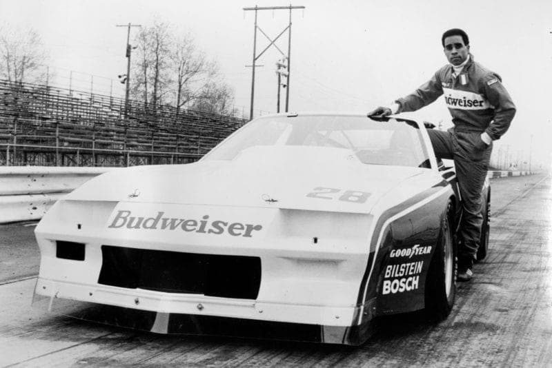 Willy T Ribbs next to his Budweiser Trans Am car in 1980