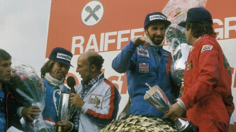 John Watson on the podium after winning at the Osterreichring in the 1976 Austrian Grand Prix