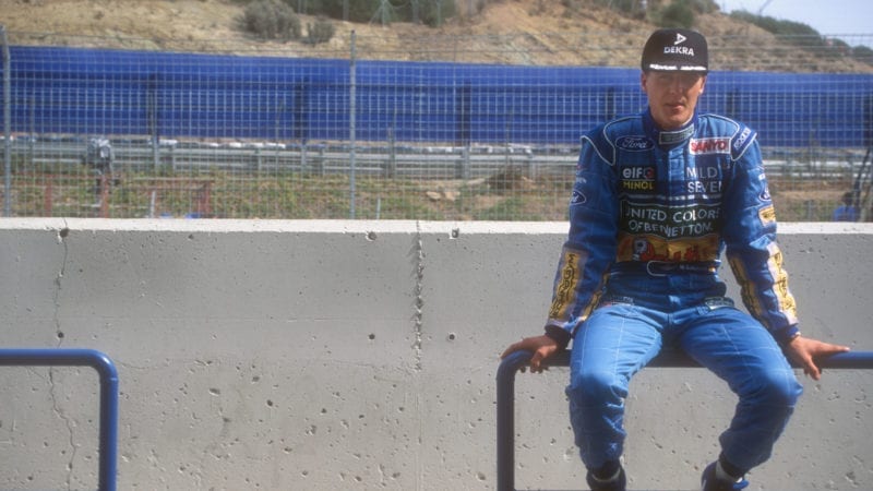 Michael Schumacher sits on a barrier