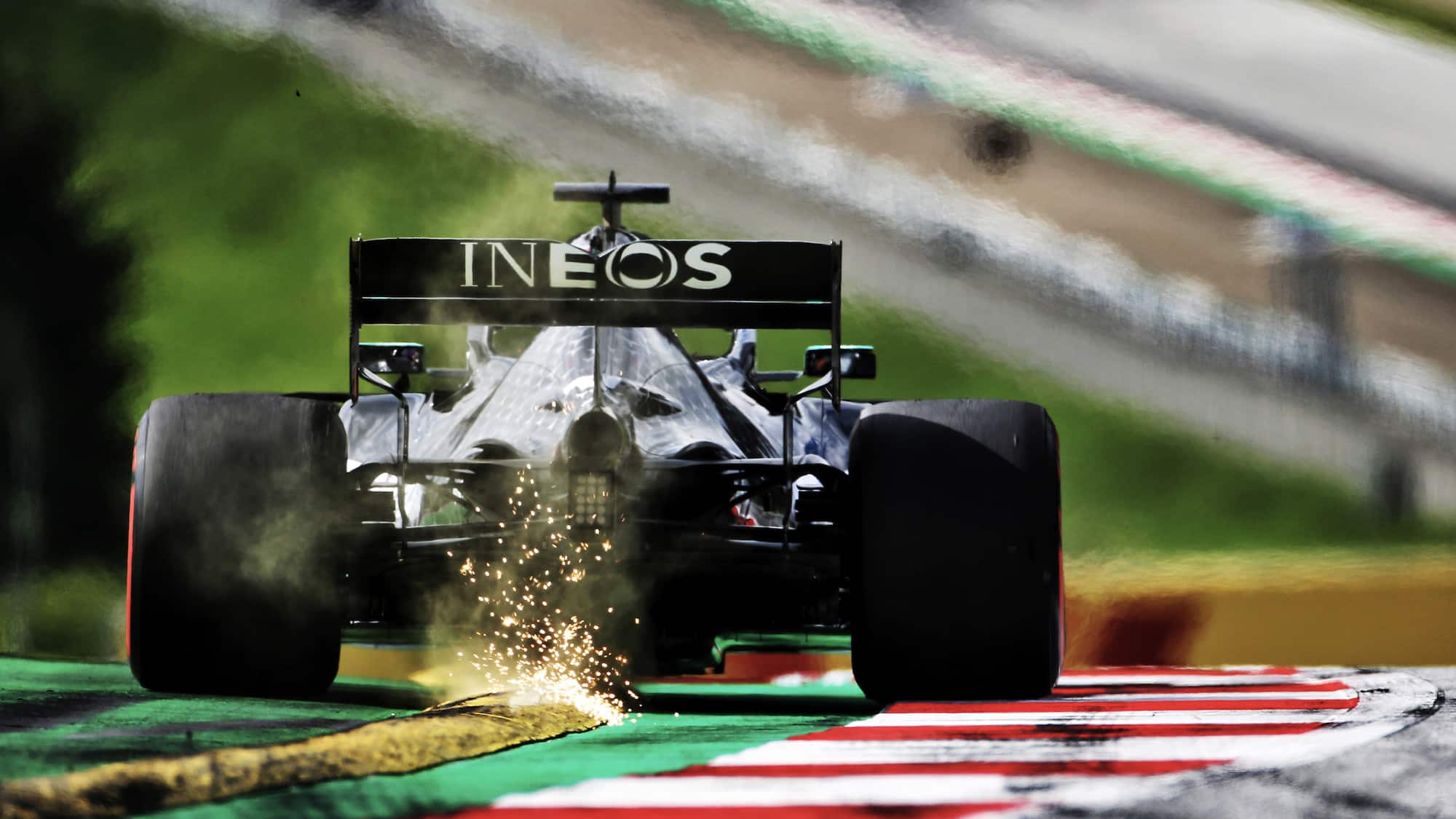 Sparks fly as Lewis Hamilton drives over a yellow kerb ahead of the 2020 F1 Austrian Grand Prix