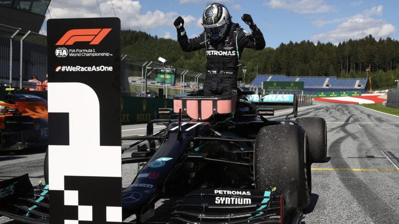 Valtteri Bottas holds his arms in the air as he steps out of his car after winning the 2020 F1 Austrian grand prix