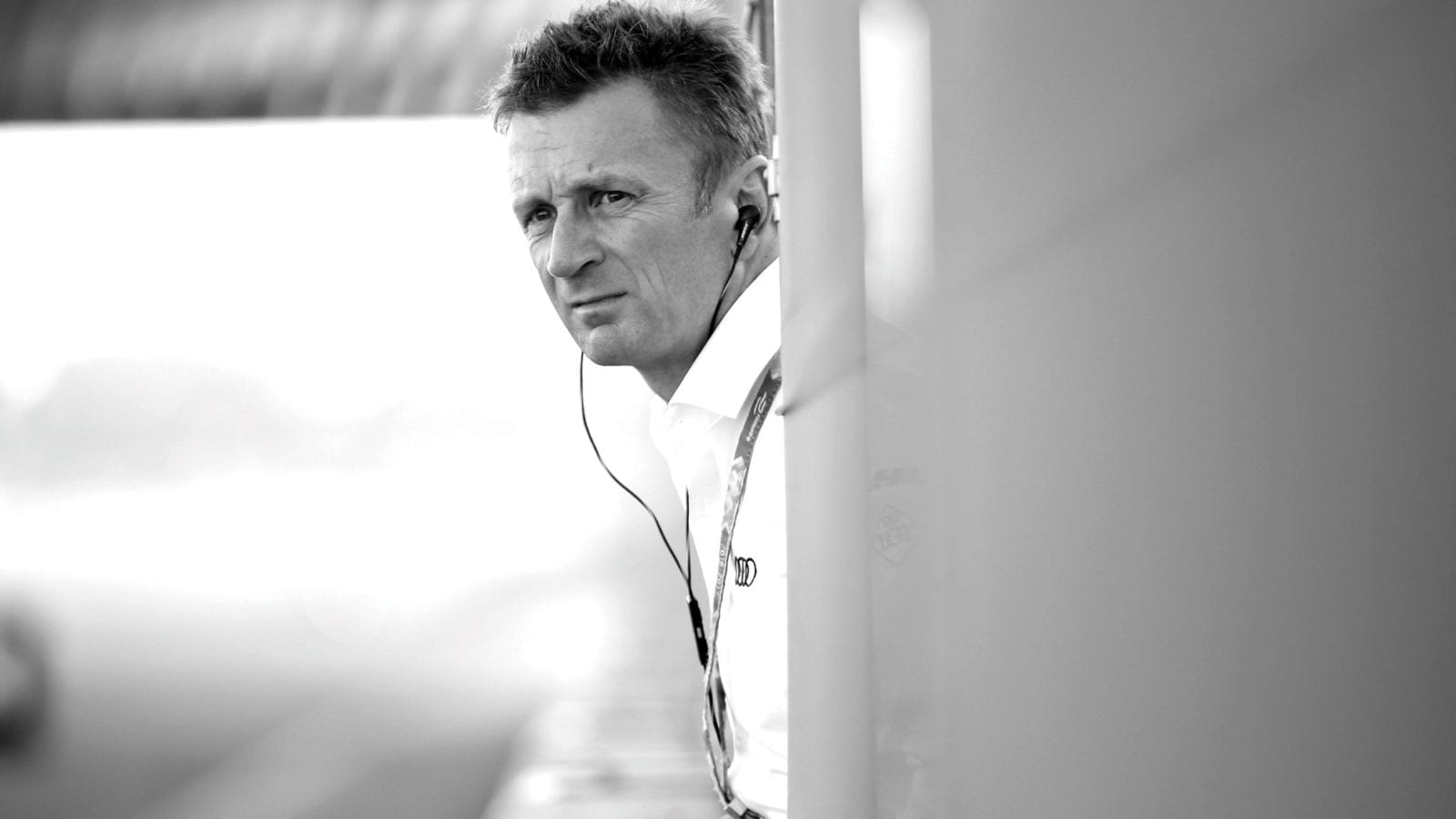 Allan McNish leans over to the track from a pitlane