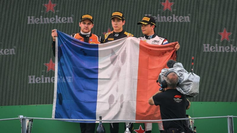 Jack Aitken Jordan king and Nyck de vries raise the french flag in tribute to Anthoine Hubert after a Formula 2 race at Monza in 2019