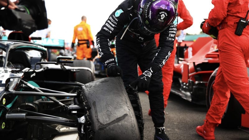Lewis Hamilton looks at his deflated tyre after winning the 2020 f1 British Grand Prix at Silverstone