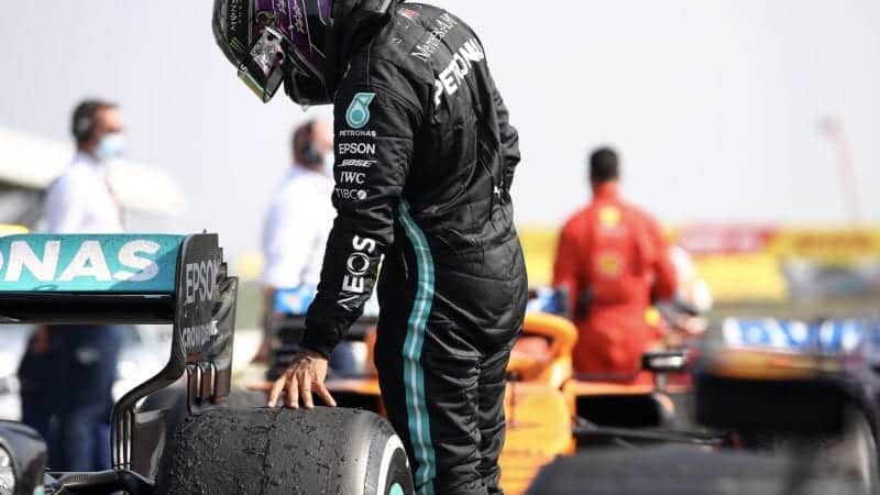 Lewis Hamilton looks at the tyre damage on Valtteri Bottas' Mercedes W11 at the end of the 2020 f1 70th Anniversary Grand Prix