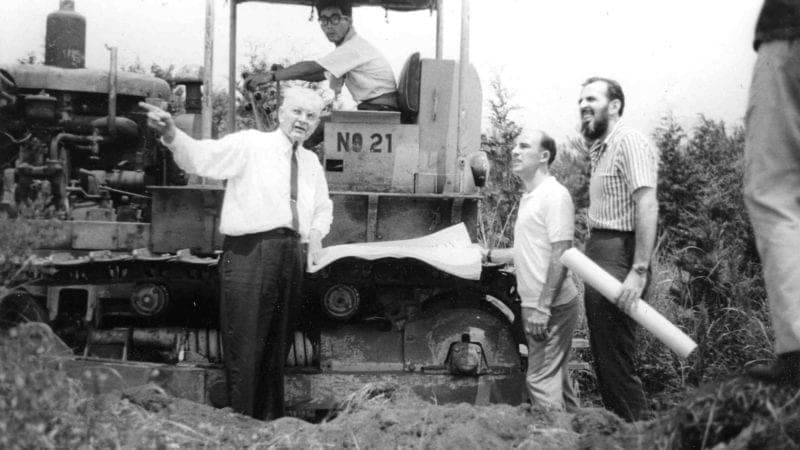Stirling Moss and Don Nichols next to a tractor at the proposed site of the Fuji Speedway