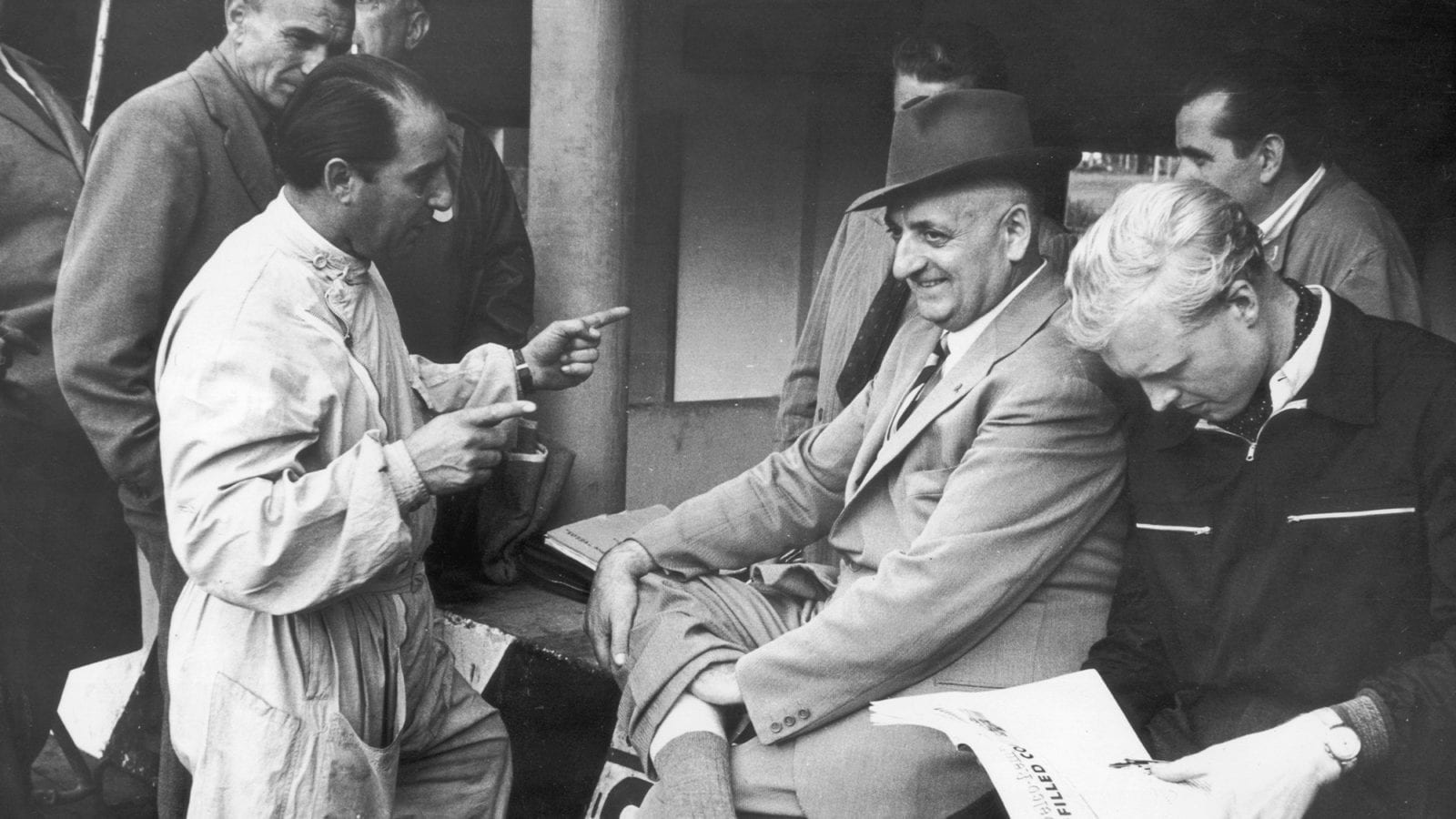 Alberto Ascari speaks with Enzo at Monza, while Mike Hawthorn reads alongside