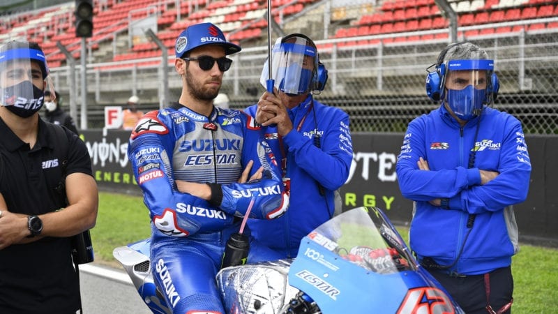 Alex Rins surrounded by team mechanics in protective visors ahead of the 2020 MotoGP Catalan Grand Prix