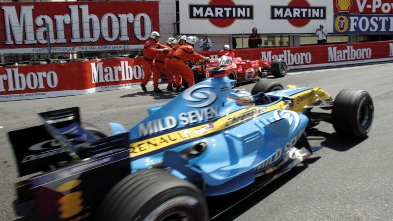 Fernando Alonso drives past Michael Schumachr's parked Ferrari in Monaco 2006