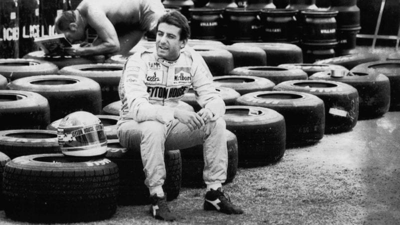 Ivan Capelli sits on tyres in his Leyton House overalls