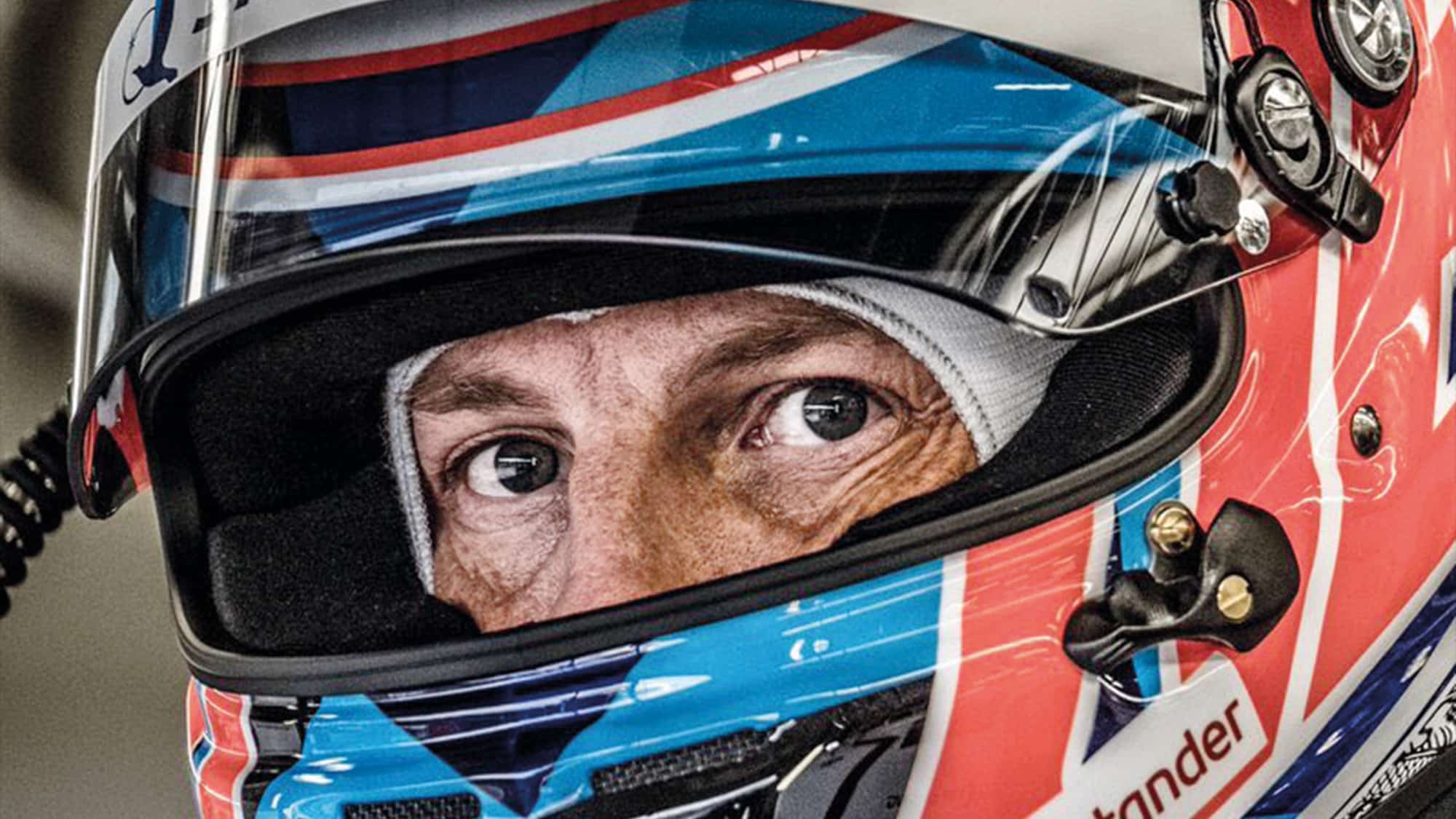 Jenson Button's eyes peer out from behind his helmet