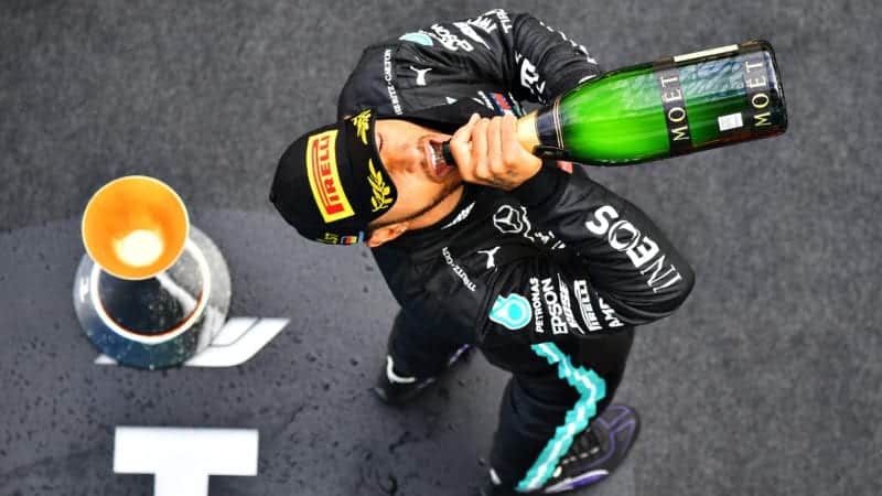 Lewis Hamilton drinks champagne on the podium after winning a record equalling 91st grand prix at the Nurburgring