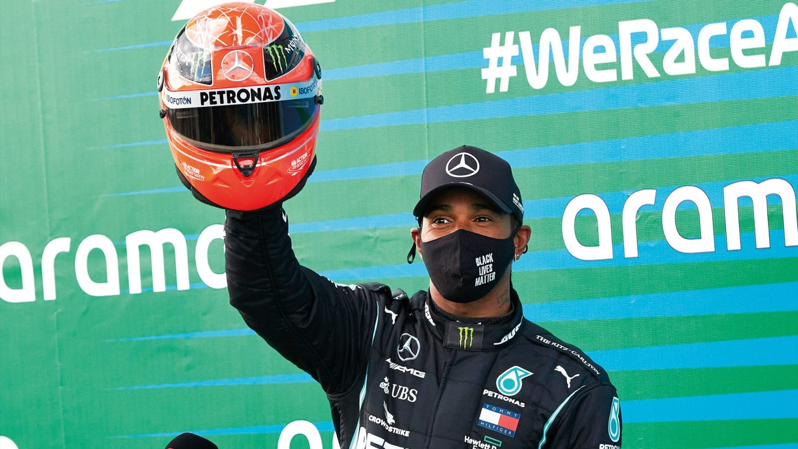 Lewis Hamilton holds up Michael Schumacher's helmet that he was given after equalling the record for the number of F1 wins atthe 2020 Eifel Grand prix
