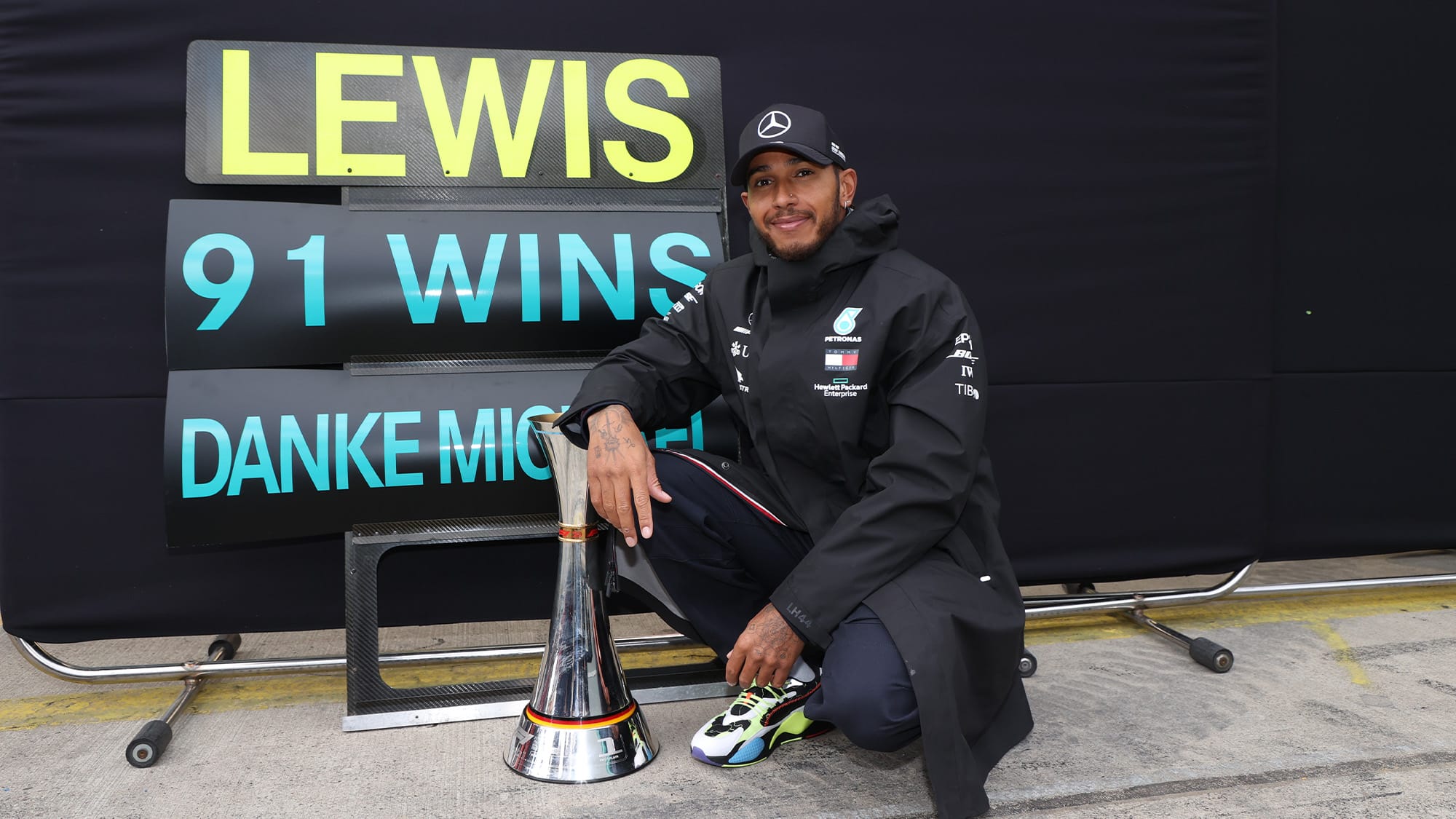 Lewis Hamilton in front of a pitboard marking his record-equalling 91st Formula 1 victory in the 2020 Eifel Grand Prix at the Nurburgring