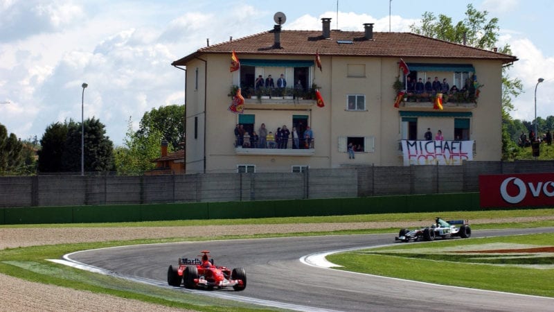 Michael Schumacher's Ferrari in front of fnas watching the 2004 San Marino Grand Prix on apartment terraces at Imola