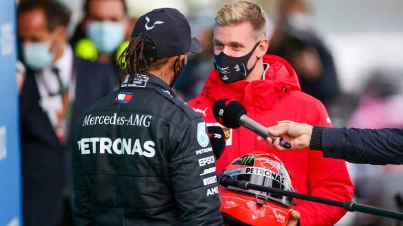 Mick Schumacher presents Lewis Hamilton with one of his father's helmets after the 2020 F1 Eifel Grand Prix at the Nurburgring