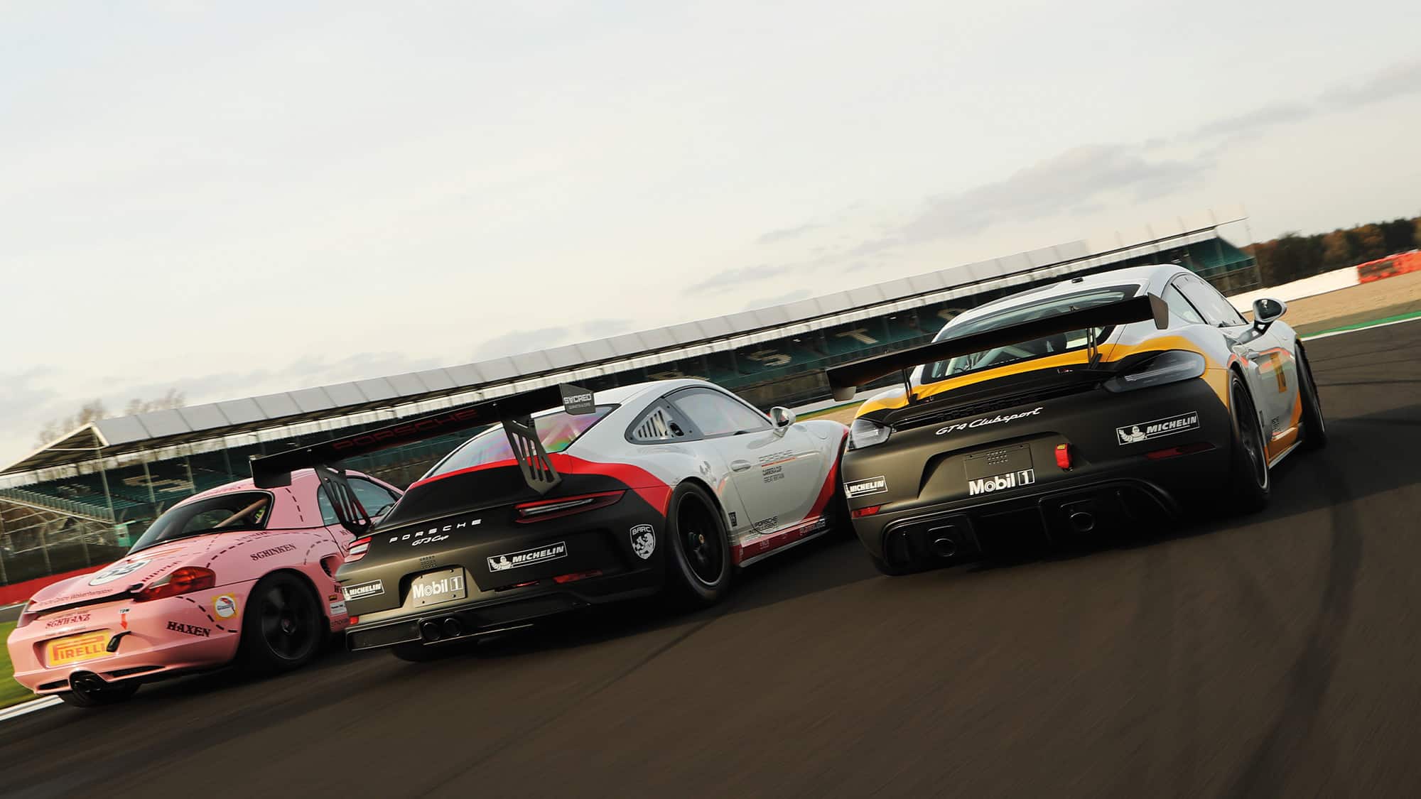 Porsche 986 Boxster S, Cayman GT4 and 911 Gt3 Cup on track at SIlverstone - rear